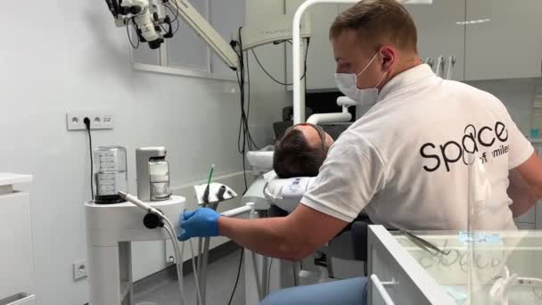 Adam Mikroskobun Yanındaki Koltukta Oturan Hastada Diş Temizleme Makinesi Hazırlıyor — Stok video