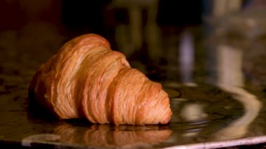 bir kruvasan mermer kahverengi tabakta duruyor eldiven eldiveni ile başka bir servis masası 2 kruvasan restoranına mükemmel hizmet veriyor titizlik sunuyor nefis bir kahvaltı günün ilk yarısı