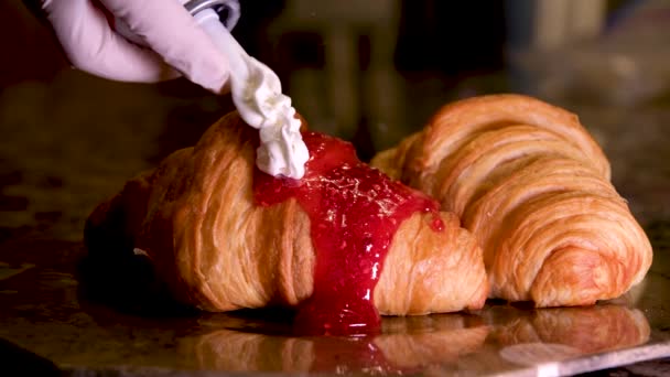 Crema Batida Una Lata Vierte Sobre Croissant Con Mermelada Frambuesa — Vídeo de stock