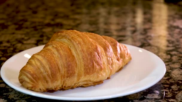 焼きたてのクロワッサン 黒い背景で回転するフランスのクロワッサン 新鮮でおいしいフランスの朝食 高品質スローモーションで新鮮なクロワッサン回転をカット — ストック動画