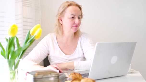 使用笔记本电脑微笑的职业成熟商业女性戴着眼镜坐在工作场所的办公桌前 快乐的老年女企业家在家里用Pc打字工作 — 图库视频影像