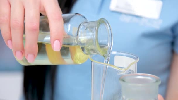 閉鎖専門家の科学者は精製工場の研究室のガラスに油から抽出された明確な黄色の液体を注ぐ 高品質4K映像 — ストック動画