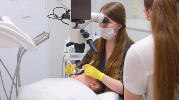 Ένας Οδοντίατρος Κίτρινα Γάντια Μαύρα Ρούχα Μια Γυναίκα Εργάζεται Ασθενείς — Αρχείο Βίντεο
