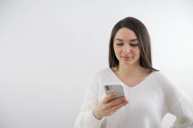 Kafkasyalı genç iş kadınının yakın çekimleri internet üzerinden modern akıllı telefon mesajı ya da mesaj kullanıyor. Kadın, cep telefonu ekranındaki internete bak. Teknoloji, iletişim konsepti