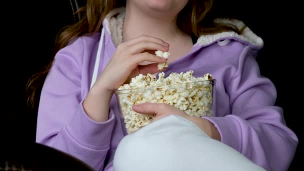年轻的中东女士待在家里 看电视 在沙发上吃爆米花 自由自在 兴奋的女士带着遥控器欣赏着有趣的电影 — 图库视频影像