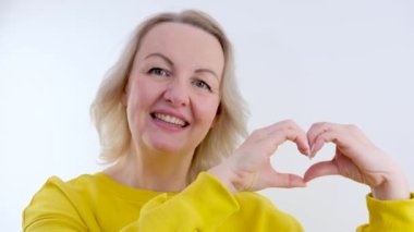 İş kadını, gri arka planda baş parmak gösteriyor. Stüdyoda göz kırpan mutlu iş kadınını kapat. Kadın profesyonel başarı işareti. Mutlu işçi kalp kaldırır yüksek kalite eller