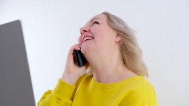 Güzel genç bir kadın mutfakta oturmuş akıllı bir telefon almış. SMS 'ler işe alma, satış büyümesi, piyango kazanma, samimi duygular ve zafer konseptini kutlayan samimi duygular hakkında harika haberler almış.