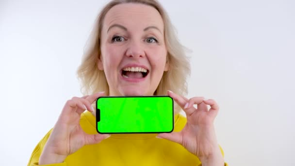 アメリカの女性は モバイルゲームで記録を披露スマートフォンで手を伸ばしや紫のスタジオの携帯電話の緑の画面にインテリジェンステストスタンドとアプリケーションの結果 — ストック動画