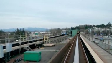 Vancouver, British Columbia, Kanada Skytrain modern şehirde bulutlu bir akşamda geçiyor..