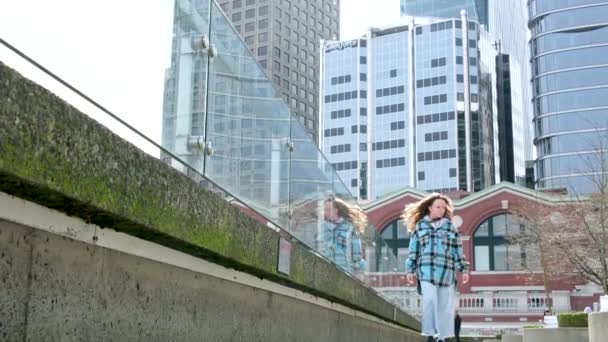 女の子はバンクーバーのダウンタウンにあるカナダプレイスの近くの遊歩道を歩く — ストック動画