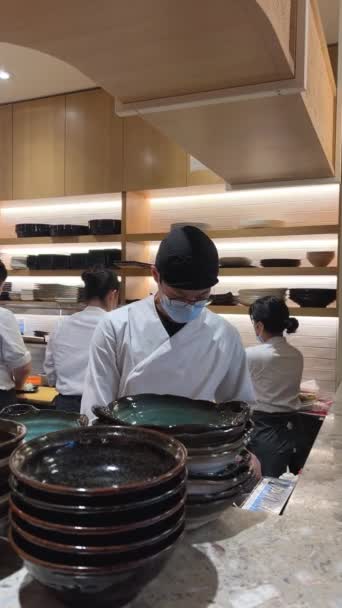 穿着面具和手套的不知名人士在寿司餐厅里为日本人准备中餐 男人和女人都穿着漂亮的围裙 衣冠楚楚 无精打采 — 图库视频影像