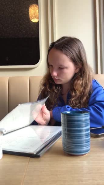 Une Adolescente Dans Café Une Table Feuilletant Menu Papier Côté — Video