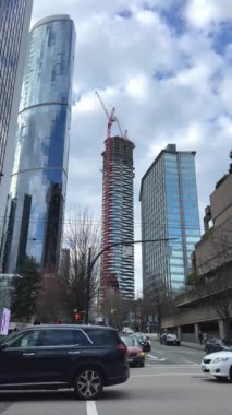 Kanada 'da gökdelenler inşa ediliyor. Vancouver şehir merkezinde mavi gökyüzüne karşı inşa ediliyor. Uzay ağaçları gibi camlı uzun bir bina.