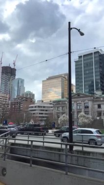 Sanat galerisi Vancouver Oteli gerçek yaşam gökdelenleri eski ve yeni evler modern arabalar gökyüzü yavaş çekim video haberleri büyük şehir Fairmont Vancouver Canada 2023 'te camlar seyahat ediyor