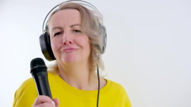 Beyaz arka planda izole bir şekilde karaoke söyleyen şık bir kadın..