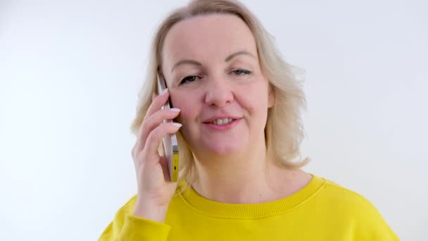 スマートフォンで話している間に離れて見て笑顔の女性起業家は 電話で楽しい会話を終了します — ストック動画