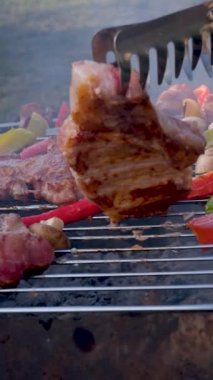 barbecue cutlets look very tasty cooked for a hamburger on a hot open fire on the grill turns over with a spatula after each turn the fire flares up and creates slow motion video for any restaurant.