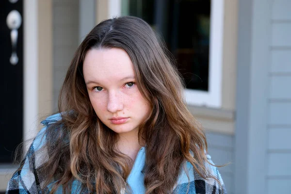 Stock image adult smart look beautiful girls teenager 14 years old looks into frame no smile against the backdrop of the house autumn-spring Cold summer strong strict look beautiful courageous strong woman