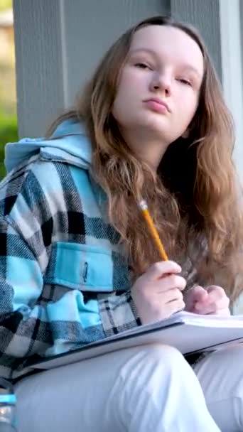 悲しいです集中顔の若いです十代の女の子保持A鉛筆で彼女の手考えそれに置くために彼女の口の場所のためにテキストトレーニング学校のレッスン思春期の子供の問題 — ストック動画