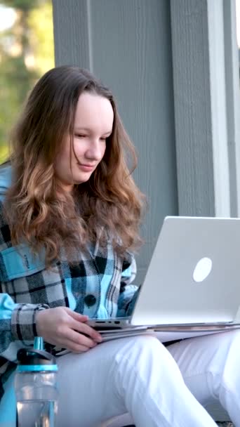 Дівчина Підліток Ноутбуком Сидить Ганку Будинку Вона Дивиться Новини Які — стокове відео