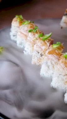 Büyük bir tabakta soslu deniz mahsulleri platası ve siyah arka planda kuru buz. Yüksek kalite fotoğraf