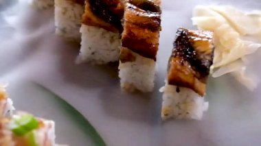 Japon Asya suşisini servis eden yemek salonu restoranı palmiye yaprağında sunuluyor kuru buharla marine edilmiş beyaz zencefil yavaşça siyah taş bir tabağa yayılıyor güzel estetik Japon Çin 'i.
