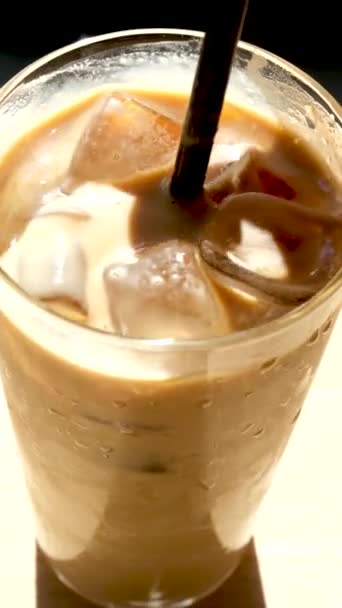 アイスクリームミルクとアイスコーヒーのガラス 冷たいコーヒーをアイスで飲む 早朝の太陽の光 スペースのコピー — ストック動画
