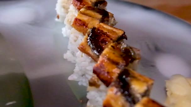 黒石板の上に異なる種類の寿司ロールの構成 箸と醤油丼が並んでいます 角度の高いビュー 高品質のフルHd映像 — ストック動画