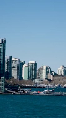 Kanada Meydanı ve Vancouver limanı ve rıhtımındaki ticari binalar gemilerin geldiği insanlar gökdelenlerde geziniyorlar Pasifik Okyanusu 'ndaki yüksek binalarda.