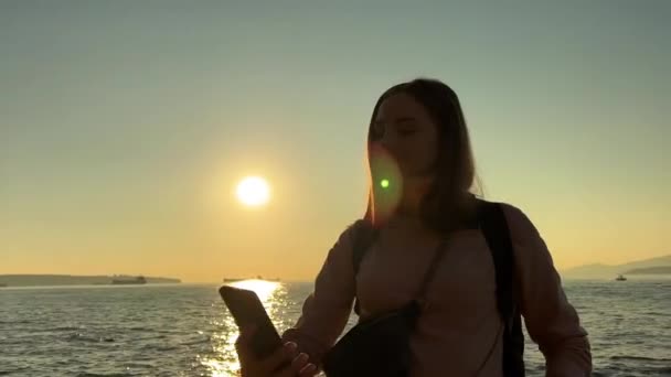 Silhouet Van Een Meisje Bij Zonsondergang Haar Handen Van Telefoon — Stockvideo