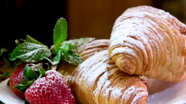 Taze kruvasanla kahvaltı, bir fincan kahve ve beyaz ahşap arka planda çilek reçeli, seçici odak. Yüksek kalite fotoğraf