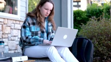 Kız, internetten hocasıyla internetten kulaklıklı dizüstü bilgisayardan öğreniyor. Çalışmak için bir arkadaşıyla konuşan kadınların portresi. Evde online öğrenim kavramı. Yüksek kalite