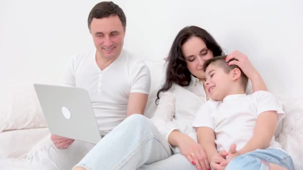 家庭与科技概念快乐的妈妈 爸爸和小男孩在家里或宾馆的床上带着平板电脑 — 图库视频影像