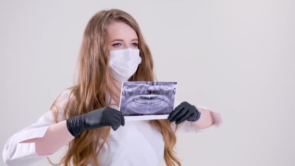 牙医手中人类下巴的X光全景人牙的X光照片 牙科医生在他的手上拿着一副黄色医疗手套牙医外科的X光全景照片 高质量的 — 图库视频影像