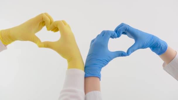 Rukavice Modré Žluté Srdce Rukama Bílém Pozadí Prostor Pro Text — Stock video