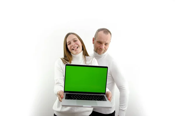 得意洋洋的女孩跳得高高的站在一位心爱的男人的身边 手里拿着一个电话 一个年轻的女人 绿色的屏幕 彩色的关键的白色衣服我们是决定命运的神 — 图库照片