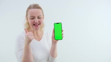 Yeşil ekran cep telefonu kromakey alanı olan yetişkin bir kadın. Gülüşmeler, gülüşmeler, sevinçler... Poof Abrakadabra 'nın ellerini kaldırması. Tamam.