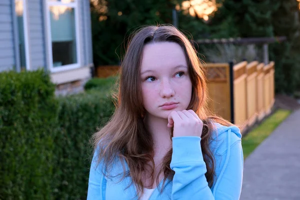 stock image Portrait of a beautiful young girl looking into camera and smiling. A charming woman dressed in a luxurious is standing on the street.