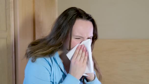 过敏的年轻女子在喷鼻涕时打喷嚏 生病的女孩得了流感或者感冒 有过敏症状不健康的女士得了季节性的病毒病 — 图库视频影像