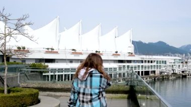 Vancouver Kanada 'da kollarını açmış neşeli genç bir kadın. Zarar veren genç bir kadın, özgürlük başarı konsepti. Yüksek kalite 4k görüntü
