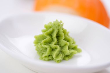 Zencefil ve wassabi içeren siyah bir arka planda, beyaz bir tabakta Japon suşisi. Yüksek kalite fotoğraf