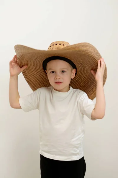 小男孩头戴夏帽 身穿夏威夷式泳衣 毫无头绪 脸上带着困惑的表情 举手表决 怀疑的概念 是的高质量的照片 — 图库照片