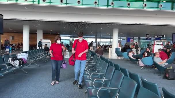 Аеропорту Чекаючи Кімнату Чоловіком Жінкою Червоних Сорочках Джинсах Масках Які — стокове відео