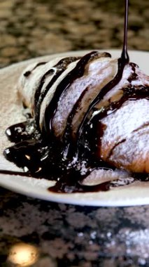 Ay çöreğinin üzerine çikolata döküldü. Tabağında kruvasan olan çikolata. Yüksek kaliteli FullHD görüntüler