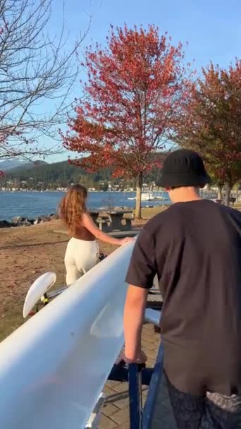 カナダでボートを漕ぐ10代の男の子と女の子は ダブルボートを水に移しますオールド ボートハウスボートセーリングパドリングセンターポートムーディーの街エスプラネード アヴェ ロッキーポイントパークレクリエーション桟橋 — ストック動画
