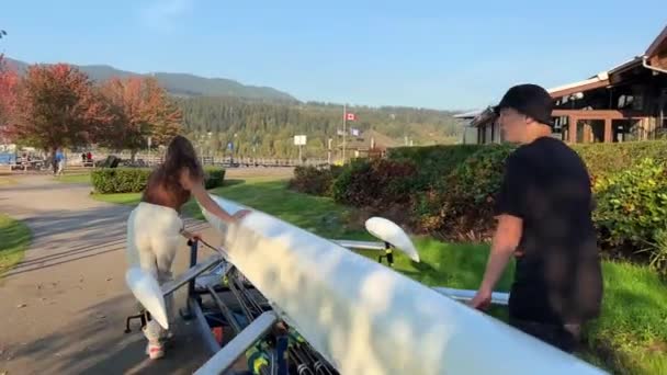 カナダでボートを漕ぐ10代の男の子と女の子がダブルボートを水上に運ぶオールド ボートハウスポートムーディエスプラネード アヴェ ロッキー カナダ バンクーバー2022 — ストック動画