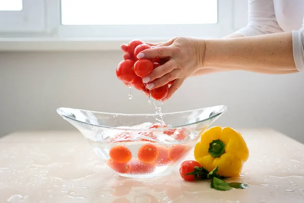 slow motion video cherry tomatoes fall into clear water a lot of splashes around on the table vegetables wash food germ protection health vitamins proper nutrition Falling red cherry tomato into water