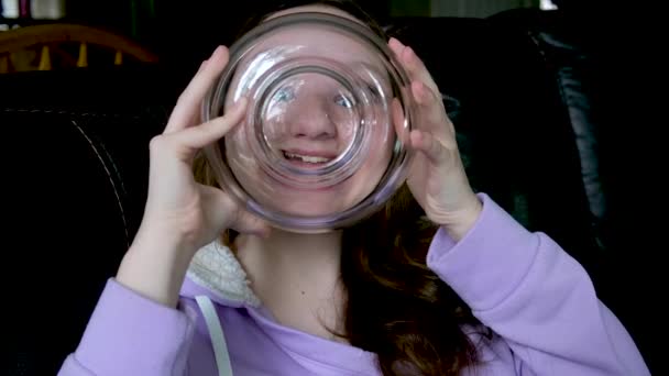 Девушка Играет Стеклянной Бутылкой Девочка Подросток Смотрит Через Выпуклые Глаза — стоковое видео
