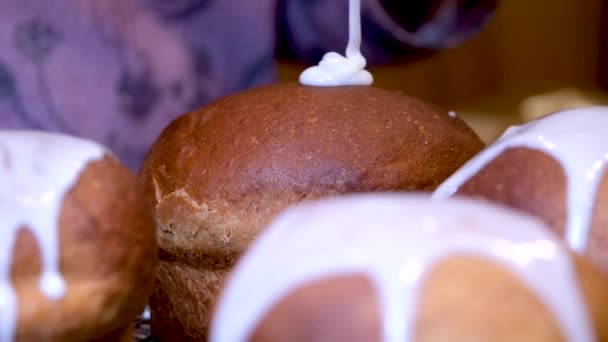 接近中だ キッチンへらはおいしい正教会のイースターブレッド 東ヨーロッパのための伝統的なロシアとウクライナのイースターケーキに白いアイシングを塗っ 灰色の背景にイースターケーキ 高品質 — ストック動画