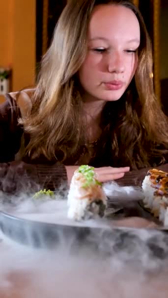 女性の手の近くに握る寿司箸とおいしい日本の寿司ロールのセット 高品質4K映像 — ストック動画